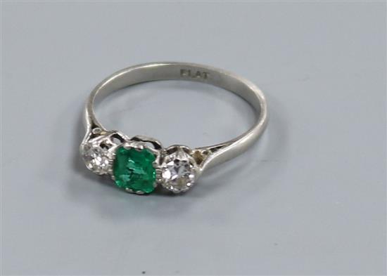 A platinum, emerald and diamond three stone ring, size O.